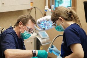 Dentist and Dental Assistant tending to a patient